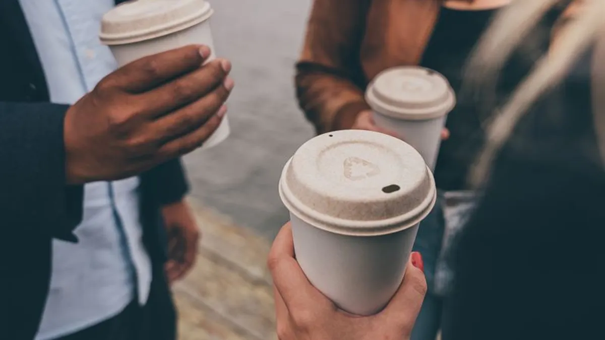 People holding coffee cups with natural-colored, fiber-based lids.