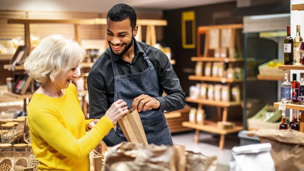 Employee at a bio grocery shop helping a customer