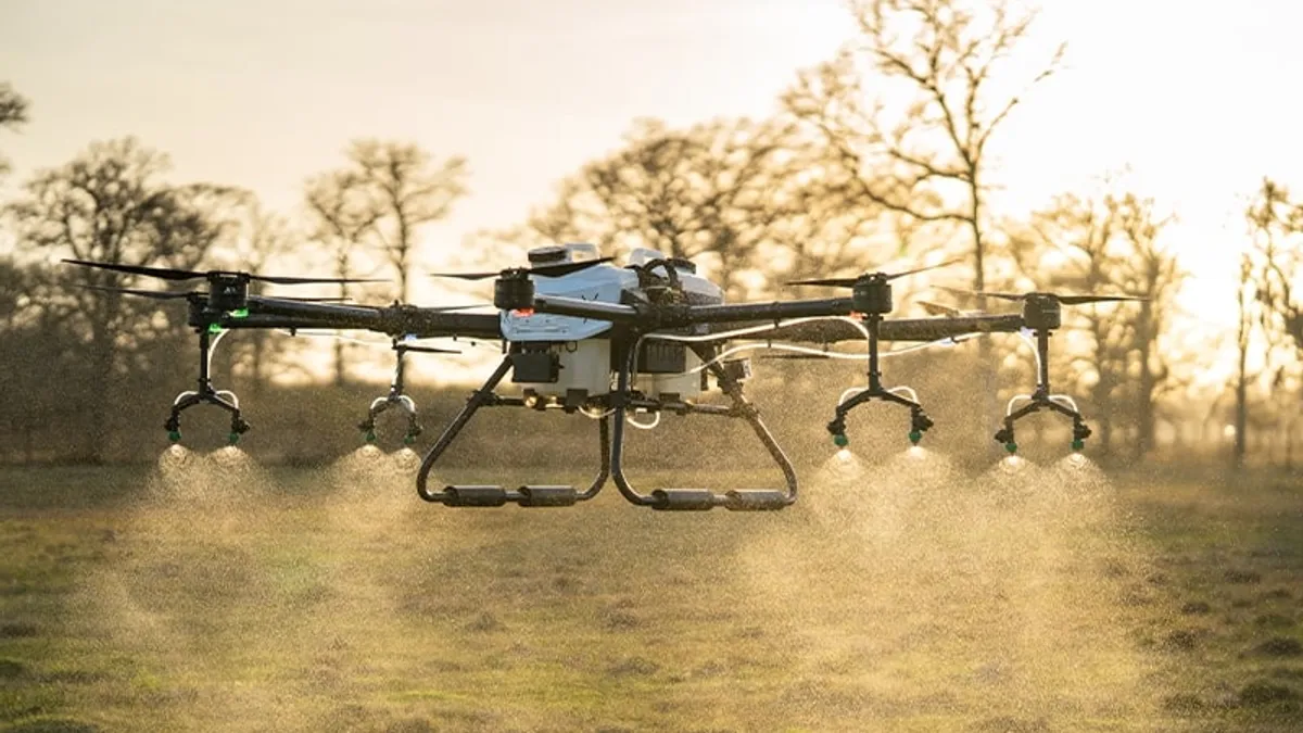 A Hylio drone sprays amid flight.