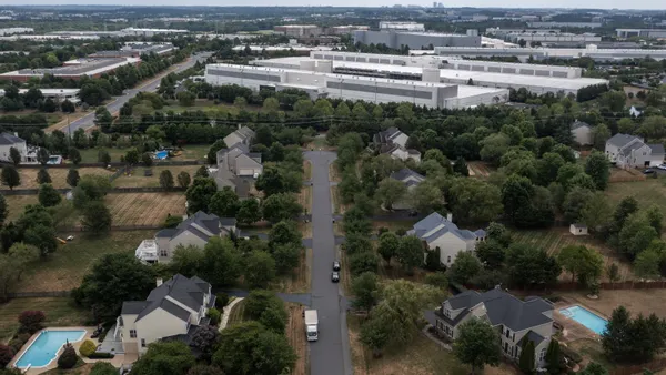 Houses sit near large data center buildings.