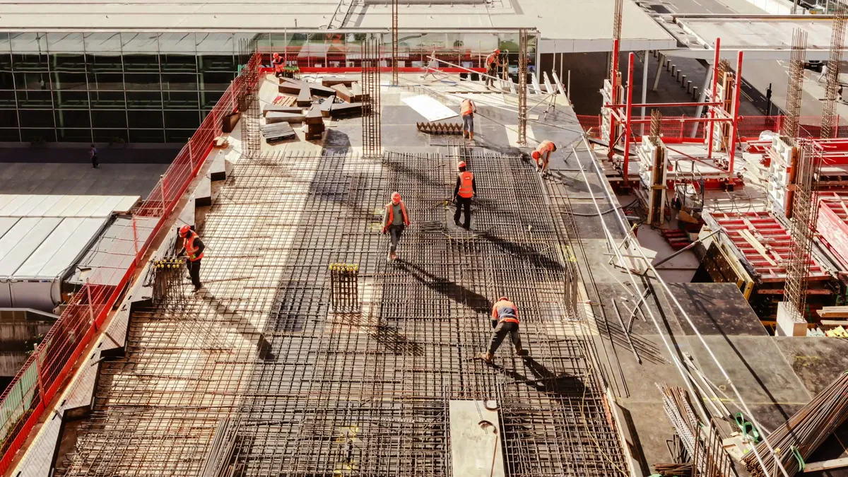 Construction workers perform jobs at a large building project.