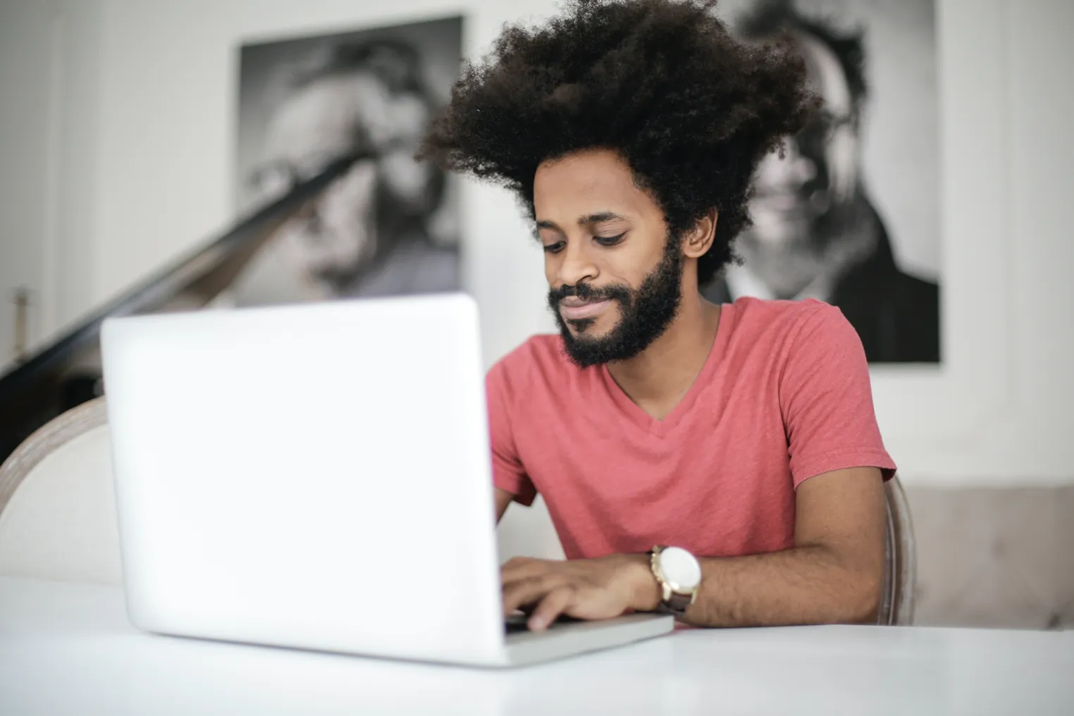 man in red shirt using a laptop