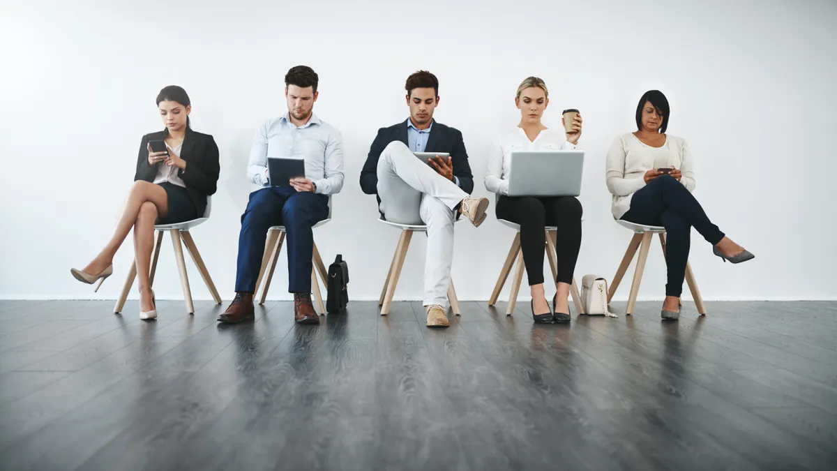 Full length shot of a group of businesspeople waiting in line for their interviews