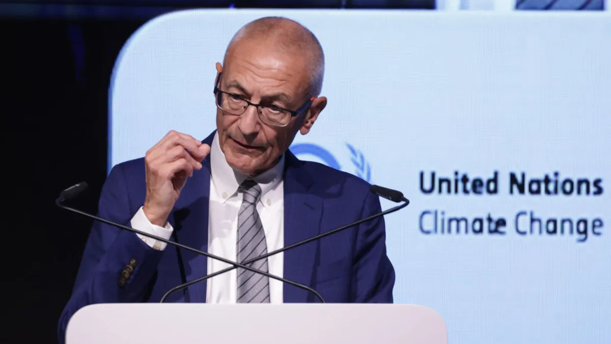 John Podesta seen speaking on stage at COP29.