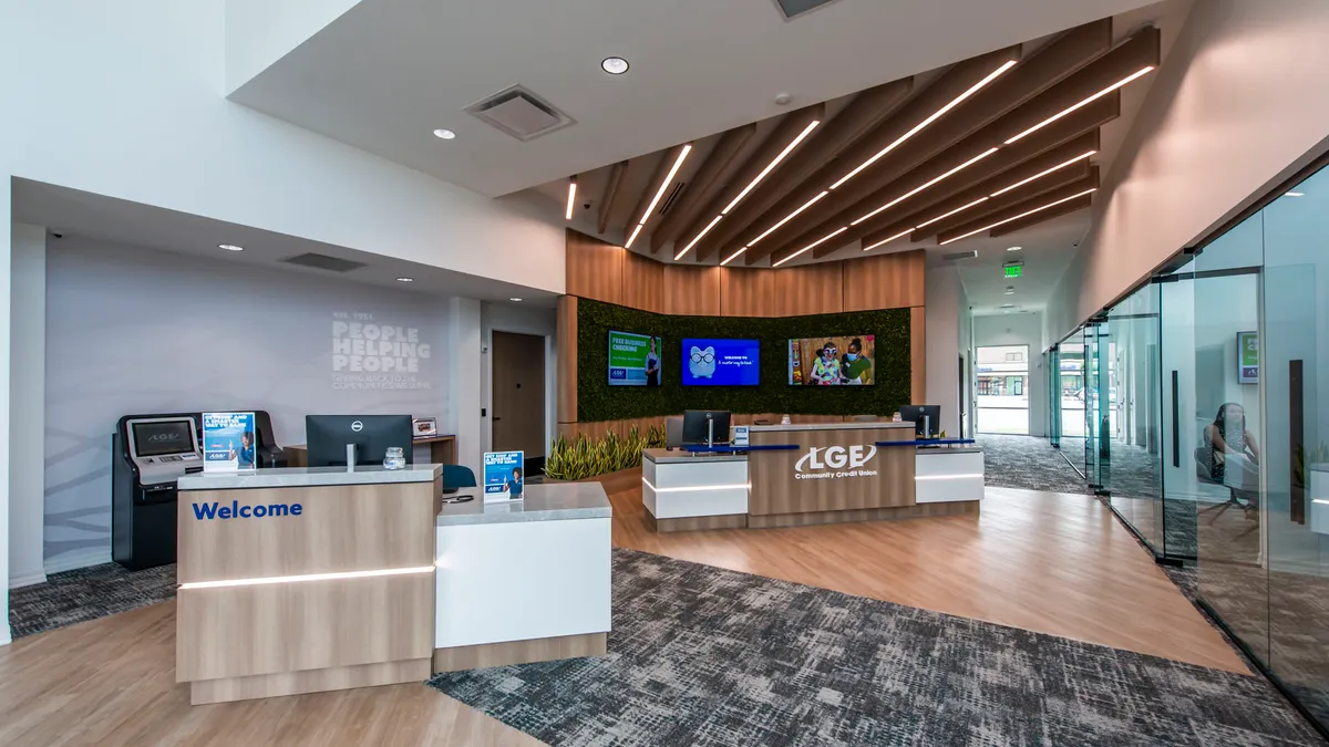 A completed, empty, modern interior of a bank. A desk that says "LGE Community Credit Union" is visible in the background.