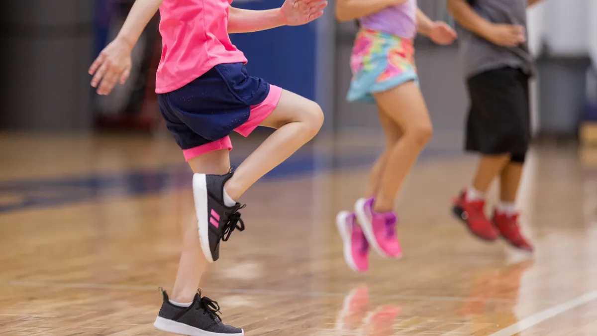 Unrecognizable elementary students warm up before PE class.