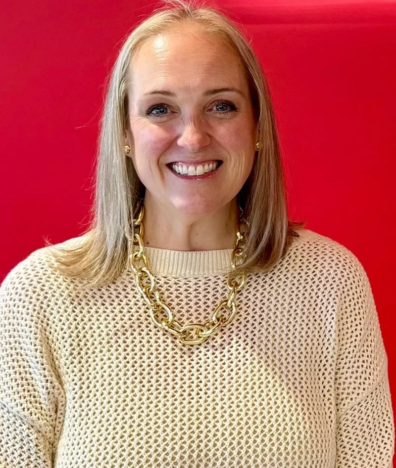 A head and shoulders photo of a person against a red background.
