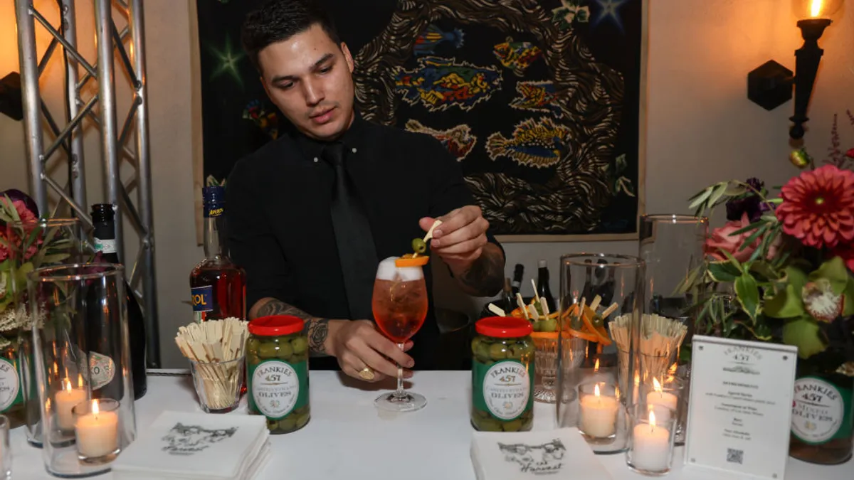 Bartender prepares Aperol Spritz signature cocktails.