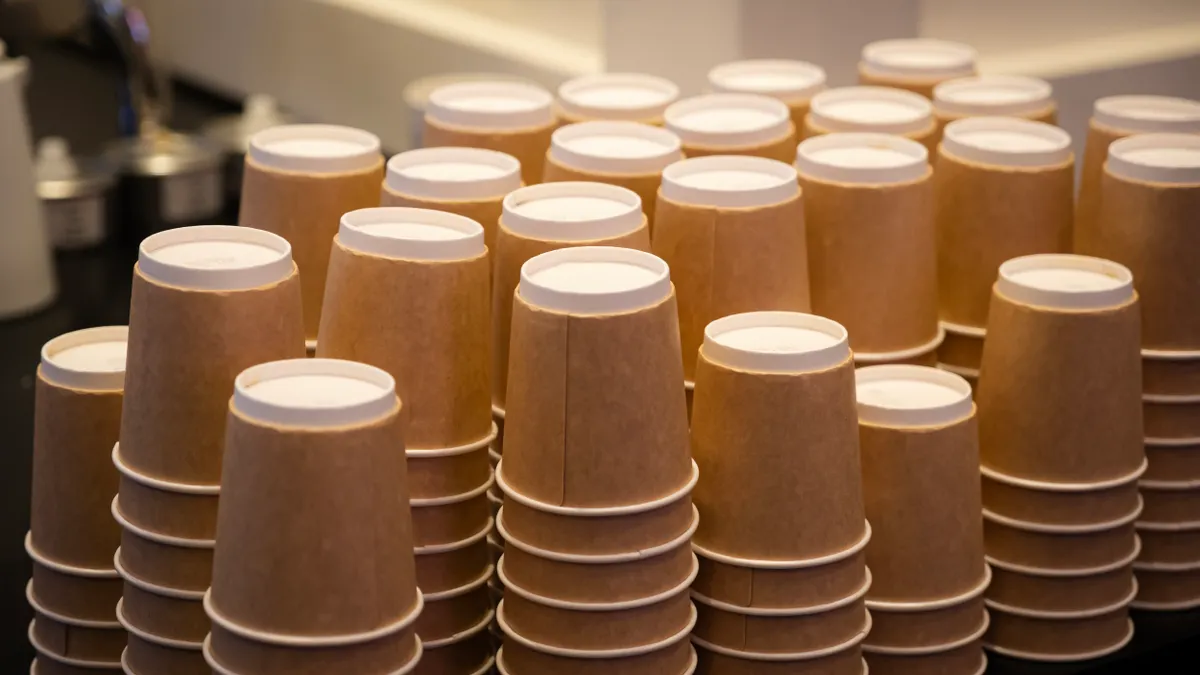 Stacks of upside down paper cups with integrated brown holders.