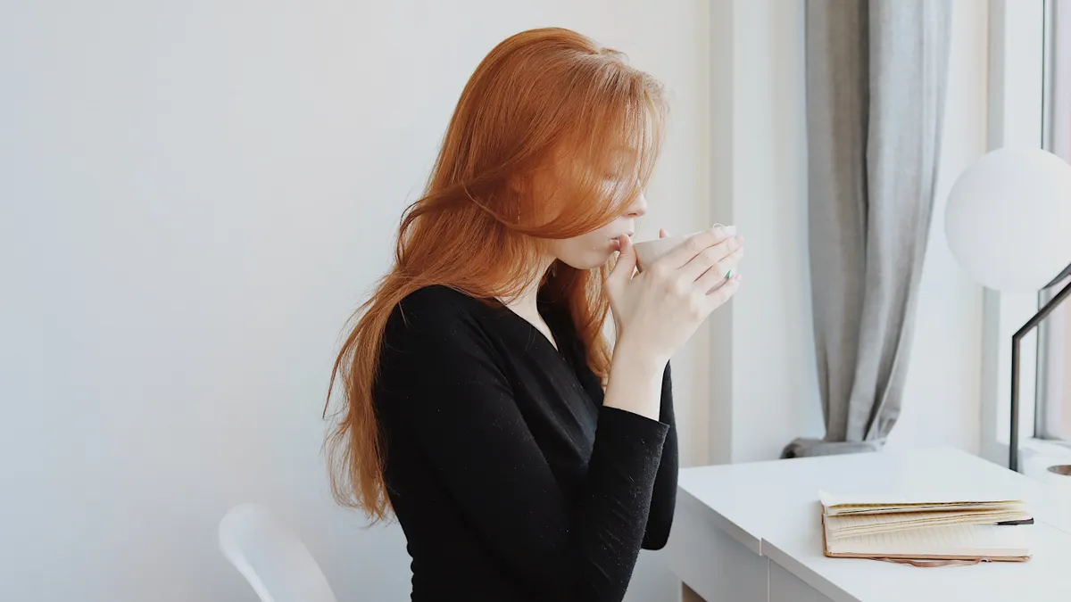 A White woman drinks coffee while working from home