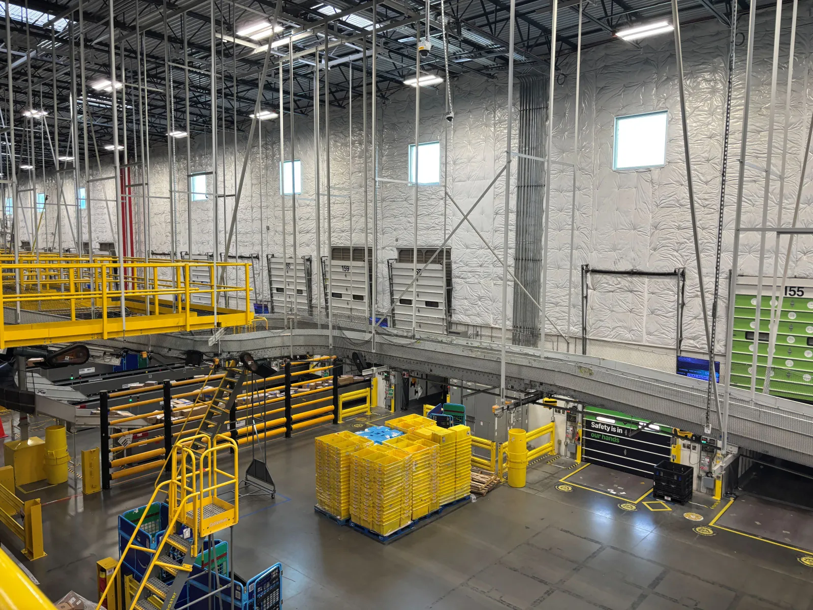 Railings and pallets sit near a loading dock inside a warehouse.