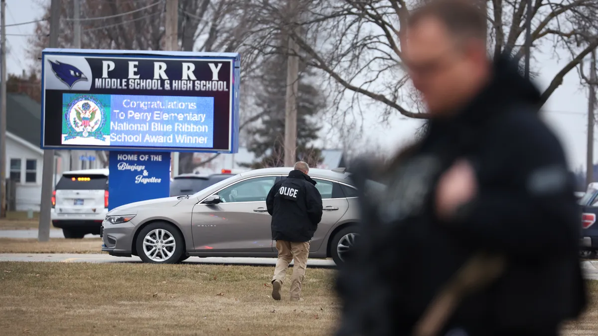 Law enforcement stand outside of Perry High School in Perry, Iowa