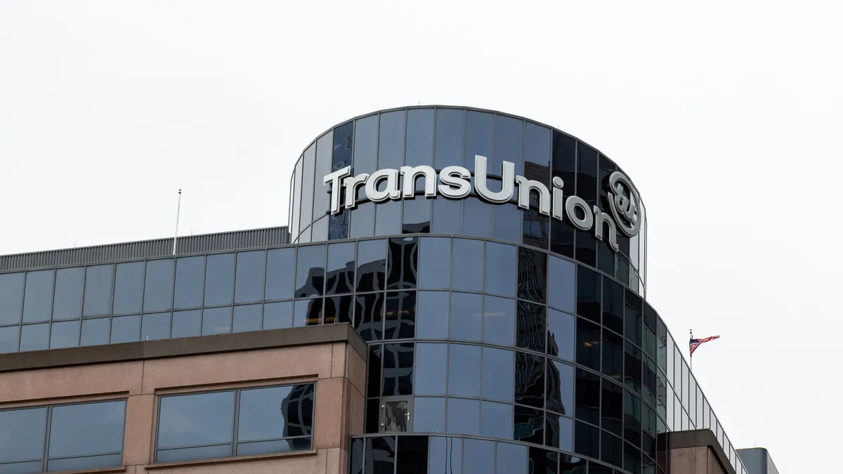 The exterior of TransUnion's headquarters building displays the company's logo with a United States flag in the background