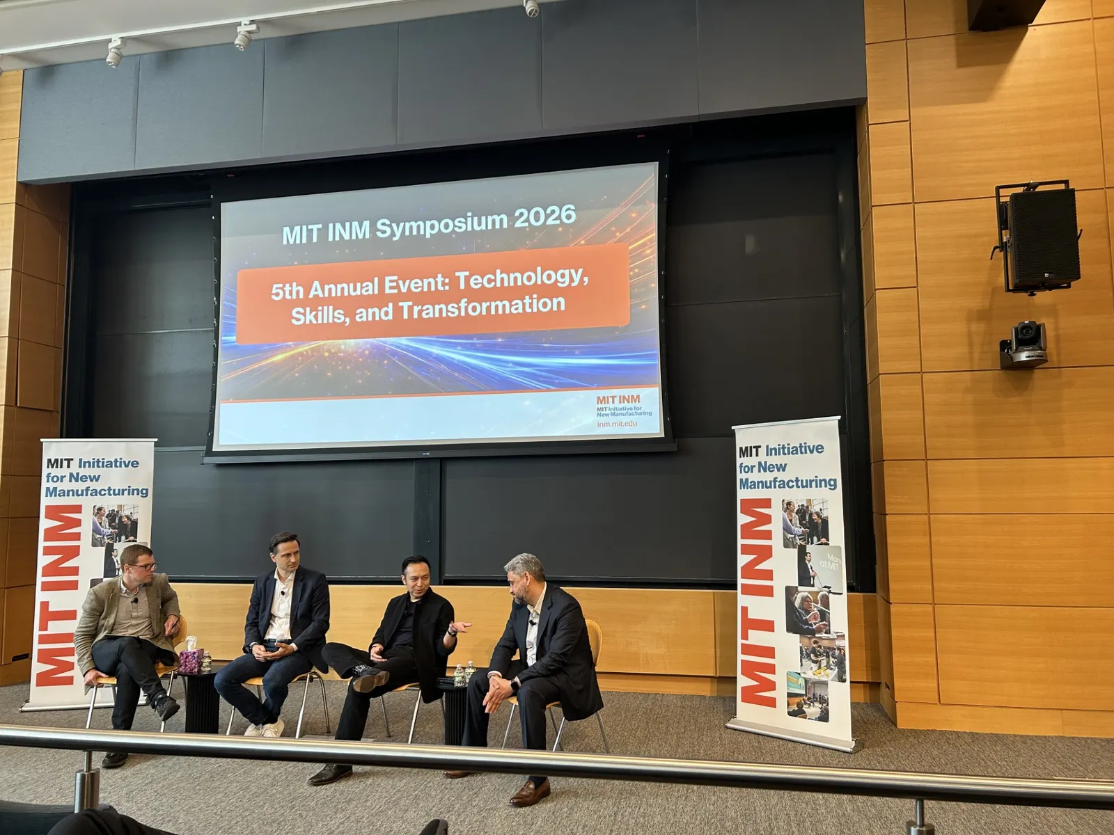 Four people sit in chairs at MIT's INT Symposium