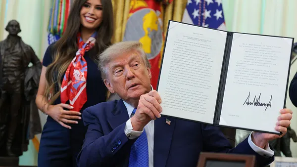 President Trump holding up an executive order on vaccines.