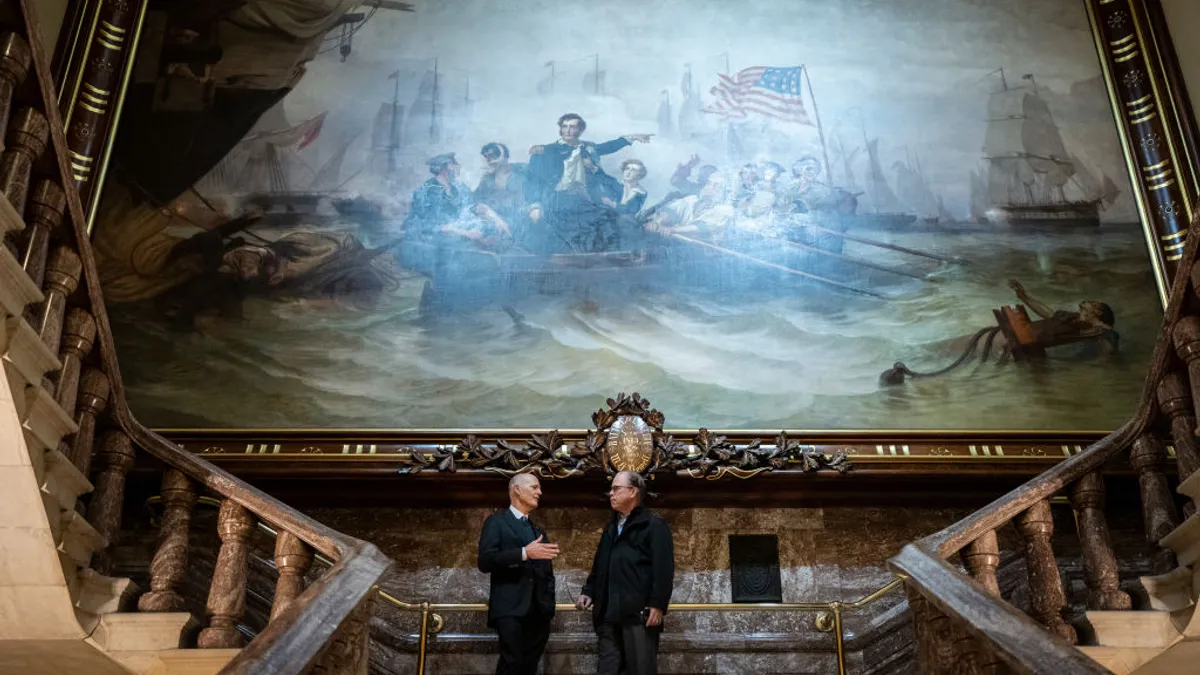 (L-R) Under the Battle of Lake Erie painting by William Henry Powell, Sen. Rick Scott (R-FL) talks with Sen. Mike Braun (R-IN) at the U.S. Capitol on December 22, 2022 in Washington, DC.