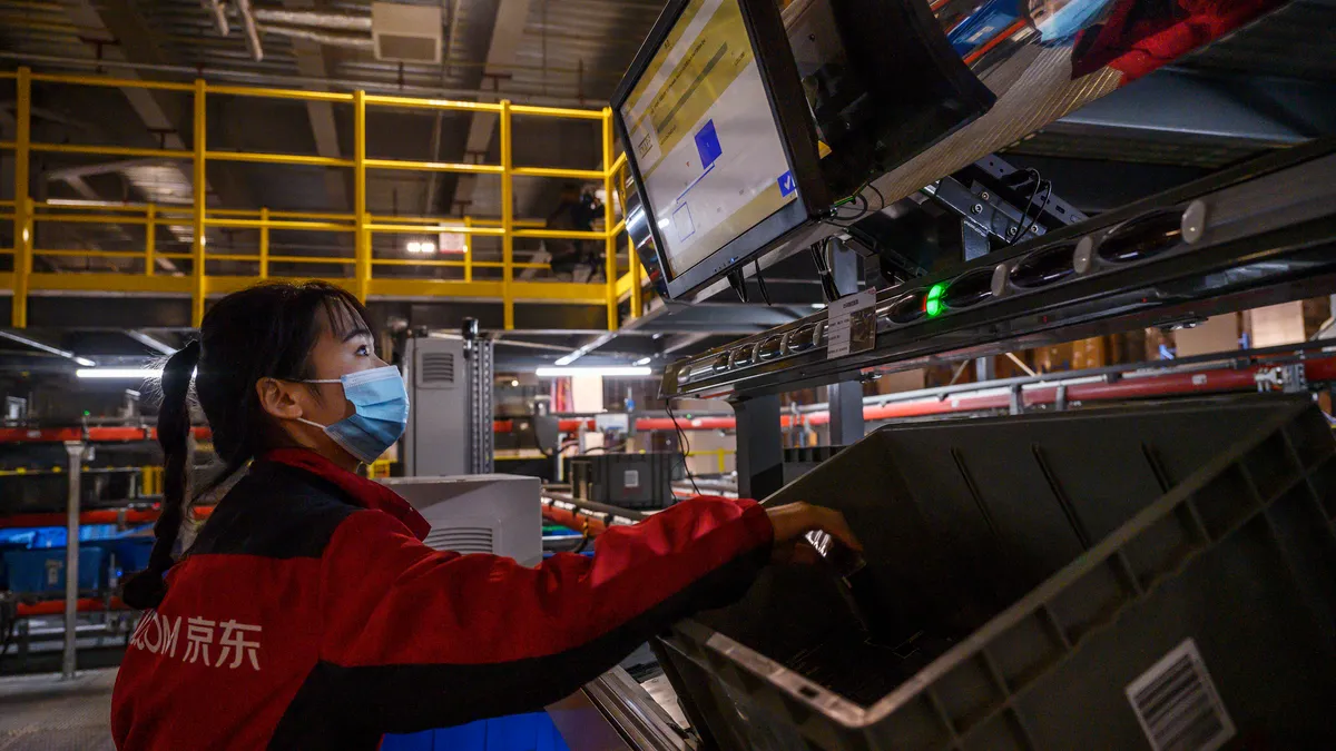 A worker from e-commerce giant JD.com works on an automated sorting machine at the company's main logistics hub.