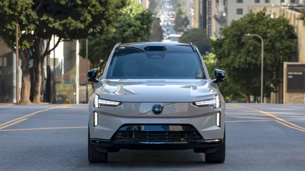 A Volvo EX90 electric SUV faces ahead into traffic, equipped with Luminar lidar for future autonomous-driving upgrades.
