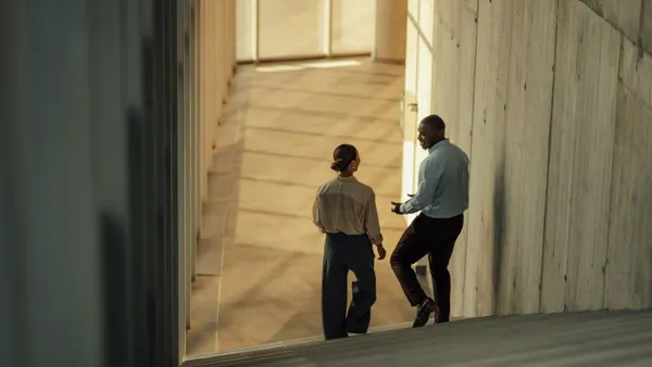 Businesspeople walking and talking on stairs in modern office building
