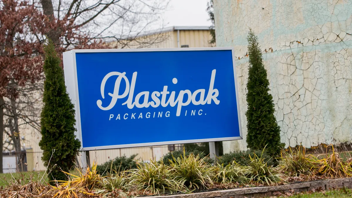 A sign outside a building that shows a logo for Plastipak.