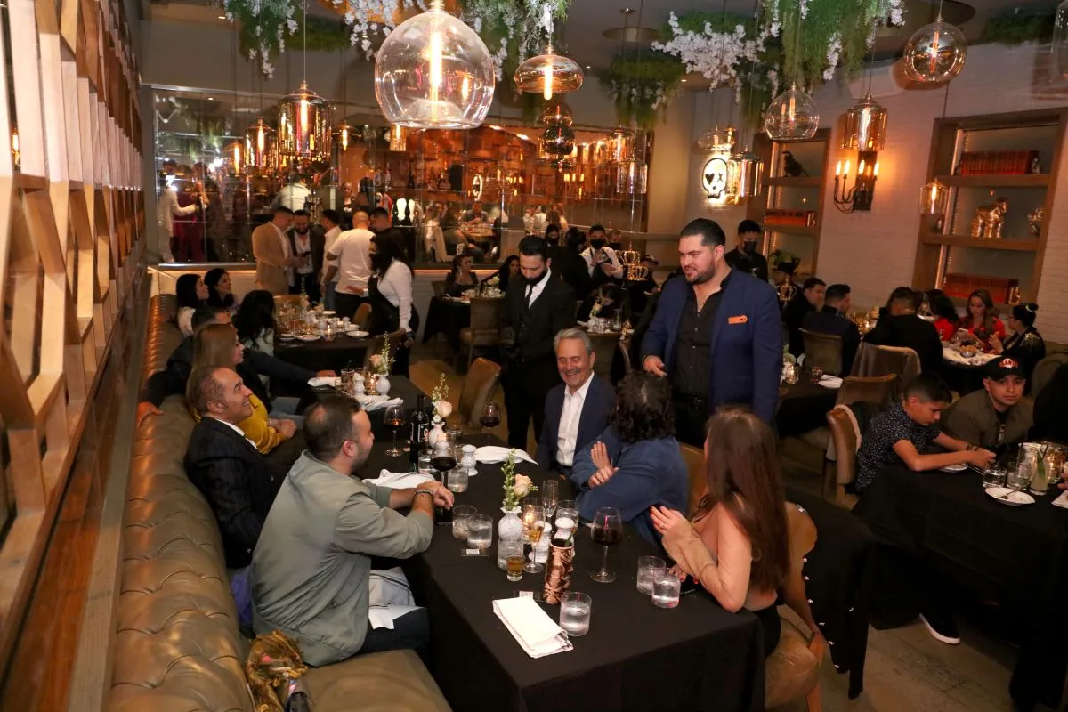 A dining room full of people talking and eating at tables.