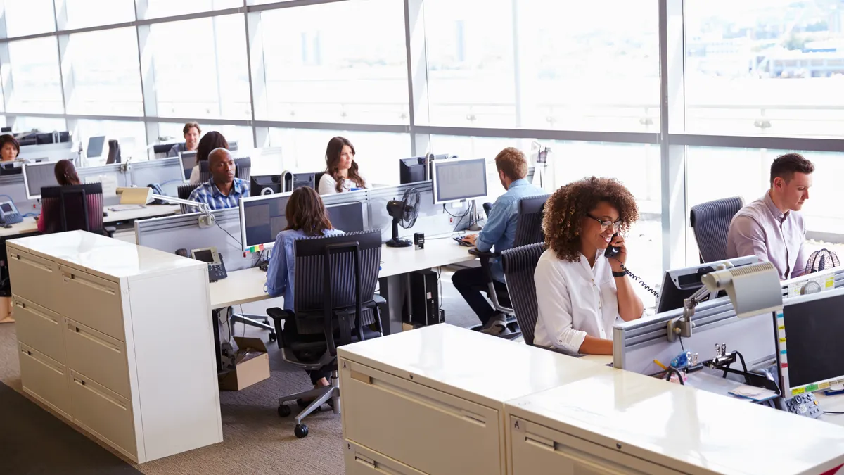 Casually dressed workers in a busy open plan office - stock photo