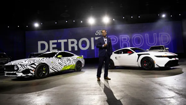 Ford CEO Jim Farley standing between two Ford models in Detroit, Michigan on Jan. 9, 2025