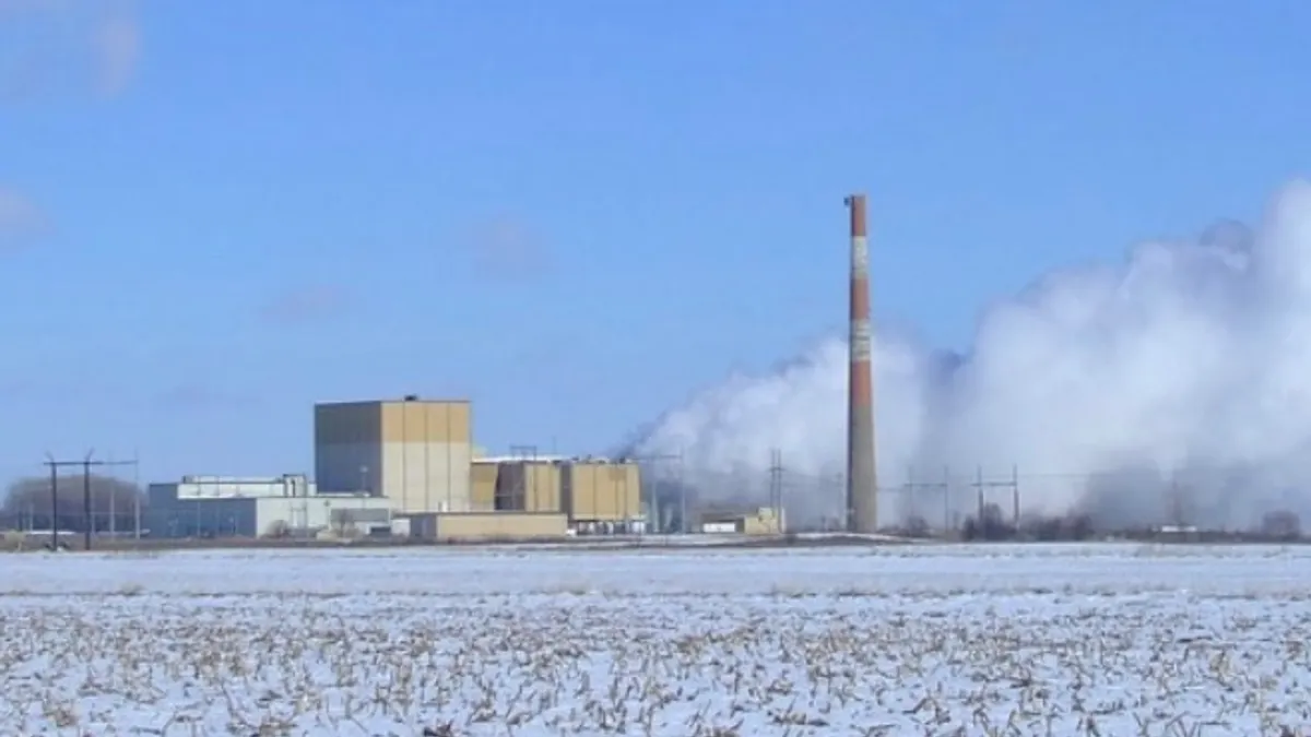 A nuclear power plant sits across a snowy field.