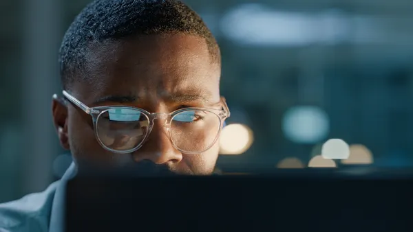 Man with glasses and computer for working in office for planning, reading and technology for connection.