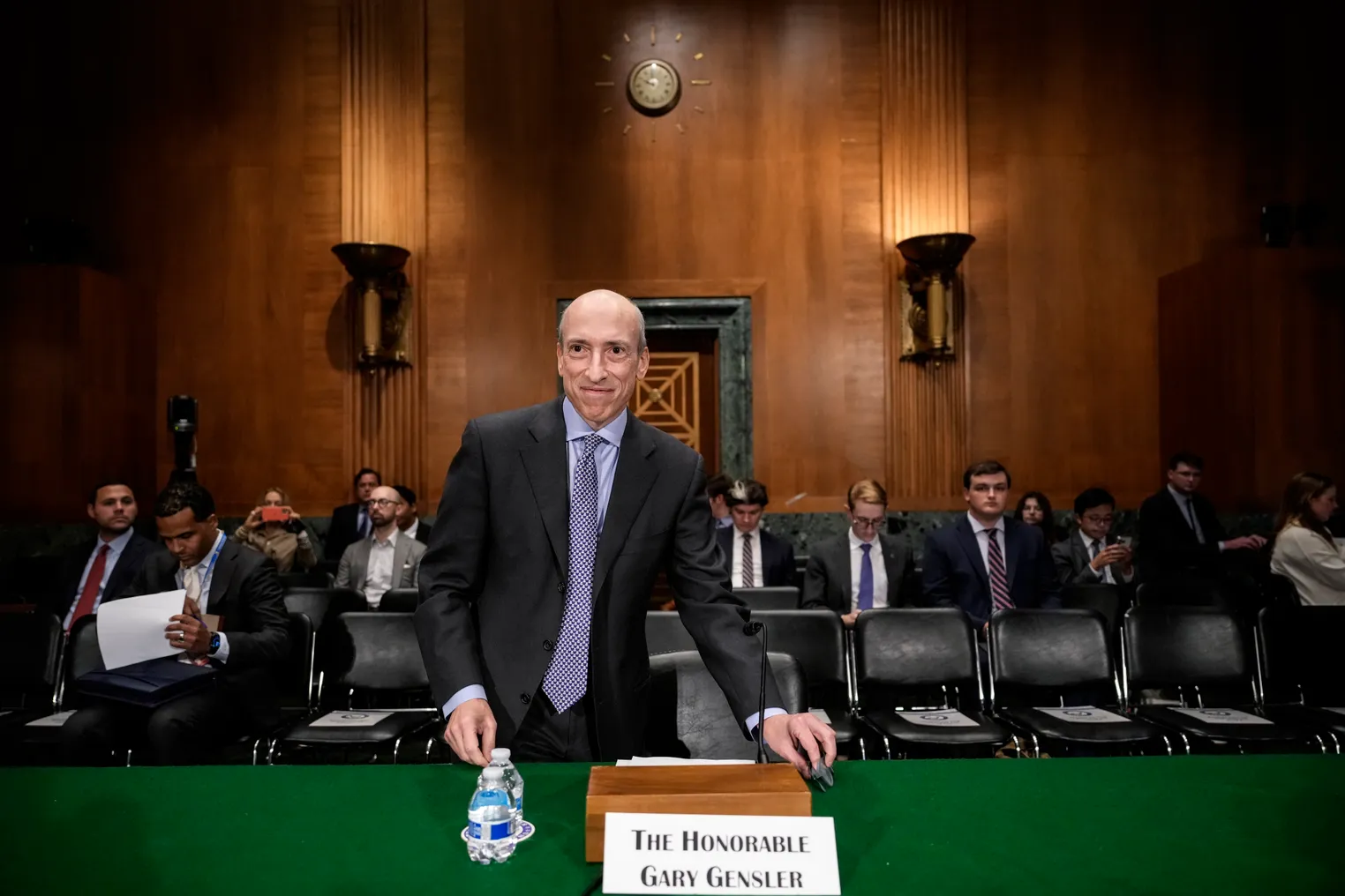 Gary Gensler smiles as he prepares to sit and testify