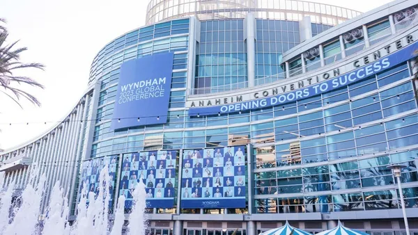 The glass exterior of the Anaheim Convention Center features blue signage denoting Wyndham's 2023 Global Conference.