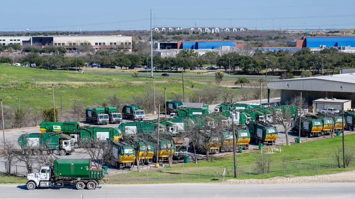 Trucks line up behind a waste facility