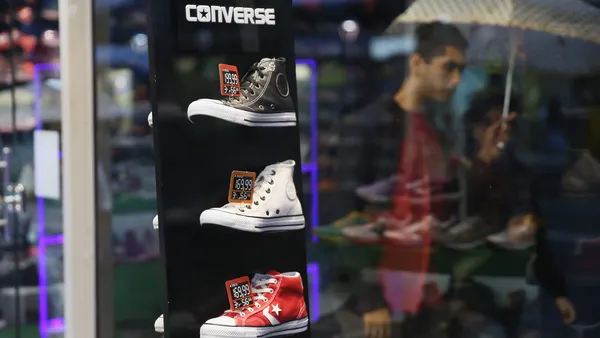 A display of Converse sneakers in a window of a store.