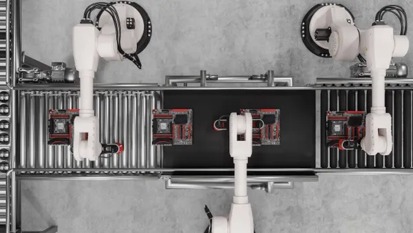 Overhead view of white robotic arms on an assembly line