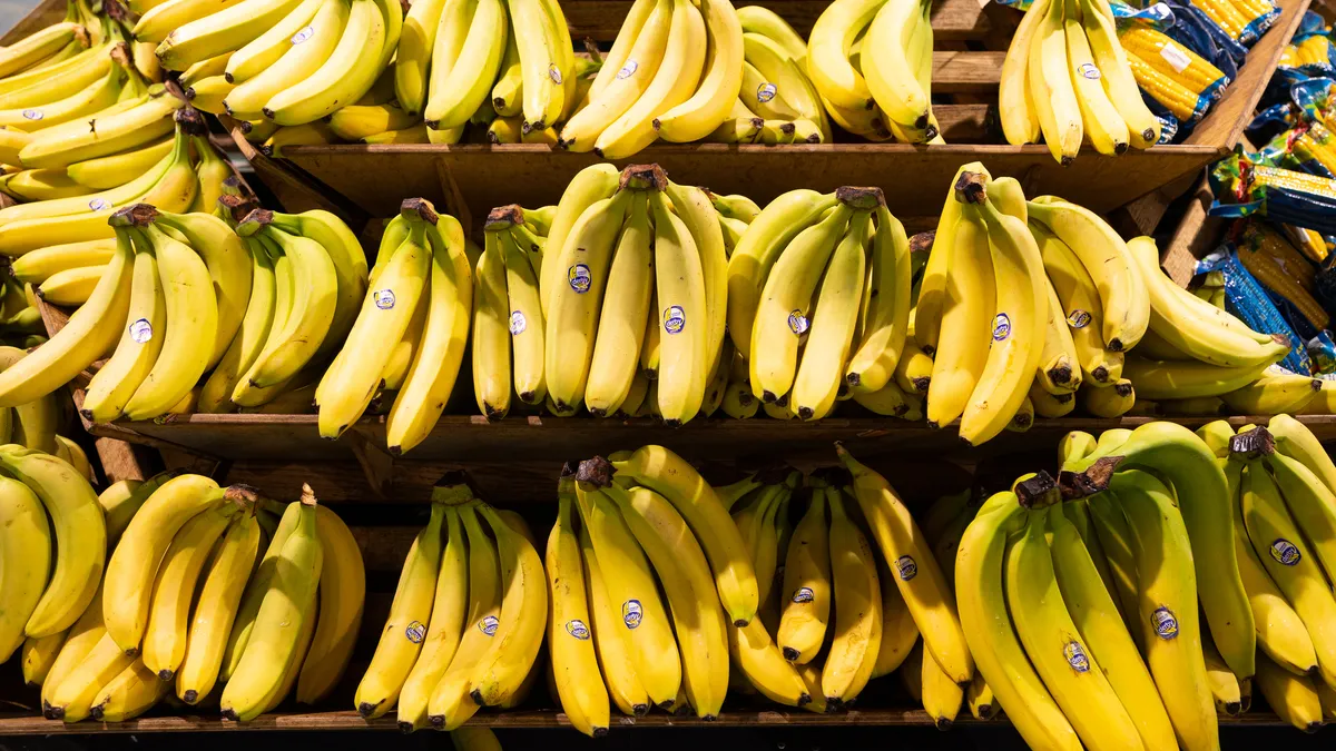 bunches of yellow bananas on shelves for sale