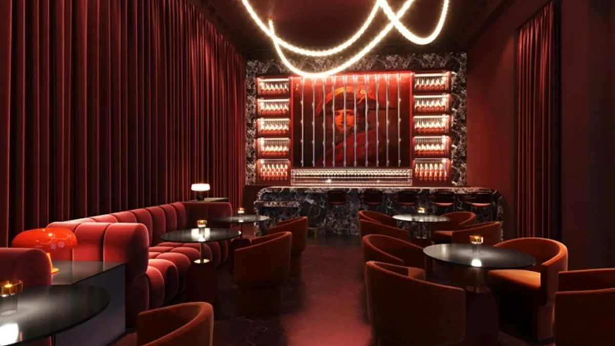 A bar with plush seating and a red-and-orange color palette.