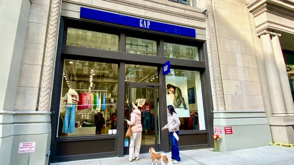 People and a dog going into a clothing store.