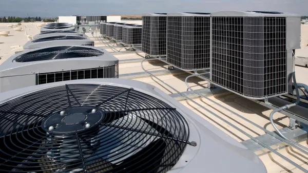 Several industrial air condtioning units on a roof.