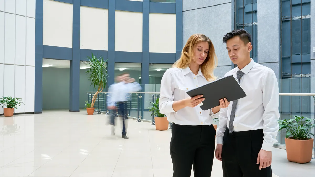 Businesspeople looking over documents at a building.