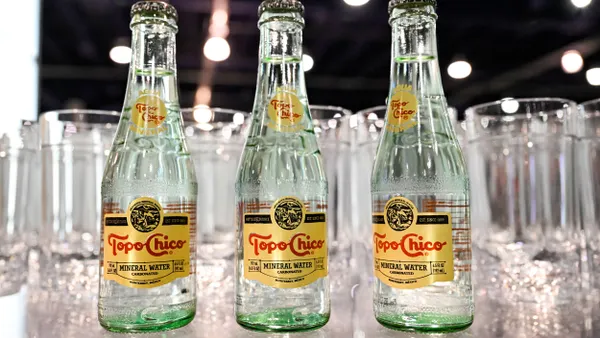 Three bottles of Topo Chico mineral water are on display.