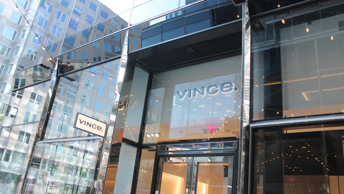 Clothing storefront as seen from outside with plate glass reflecting the street