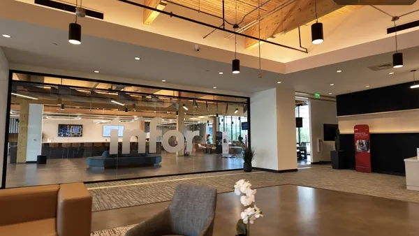 An office lobby with the Infor company name inscribed on a large glass dividing wall.
