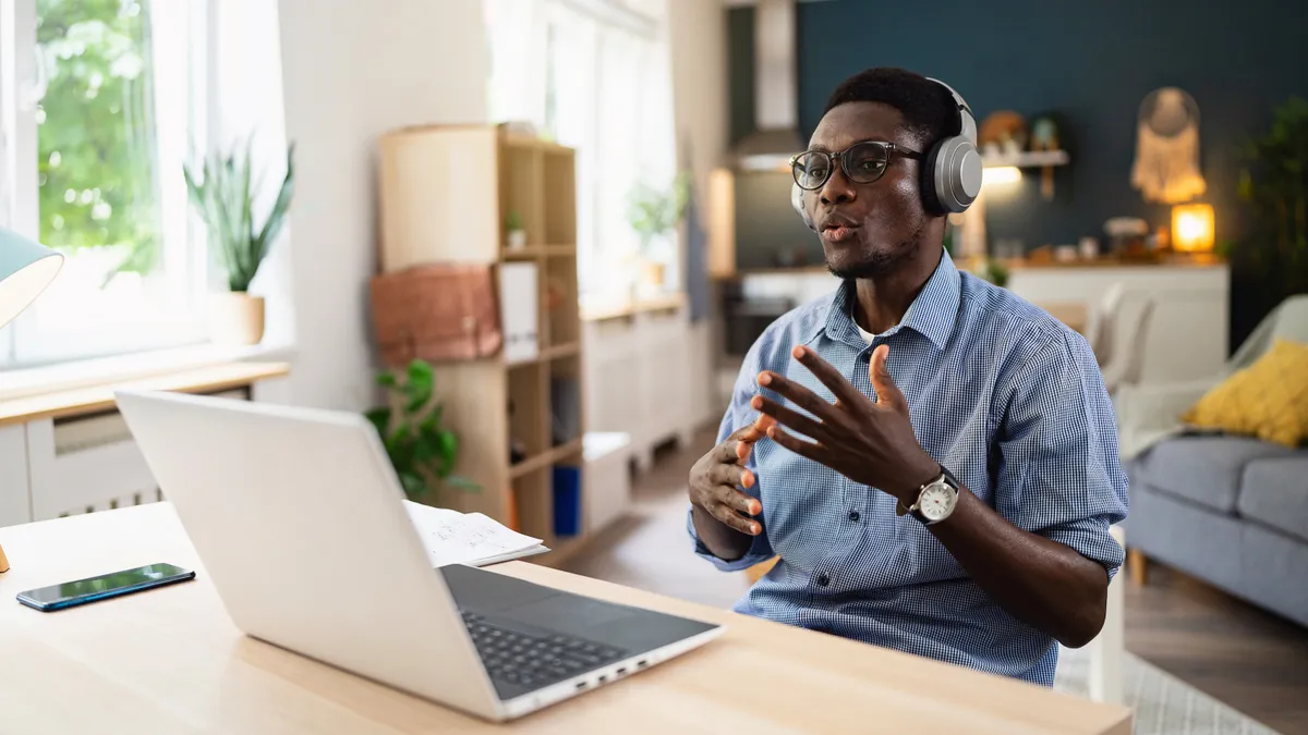 A person participates in a video call via a laptop