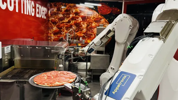 Robot arms make a pizza.