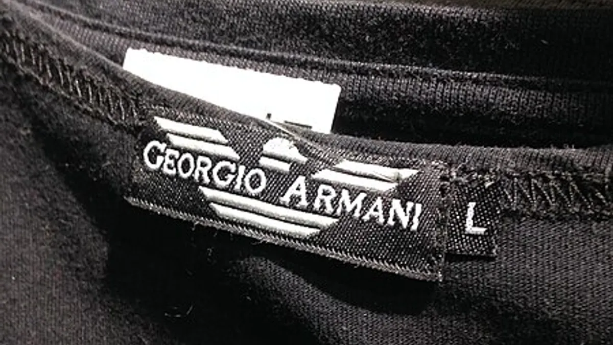 A black shirt labeled Armani is counterfeit as evidenced by the misspelling of the brand name on the tag.