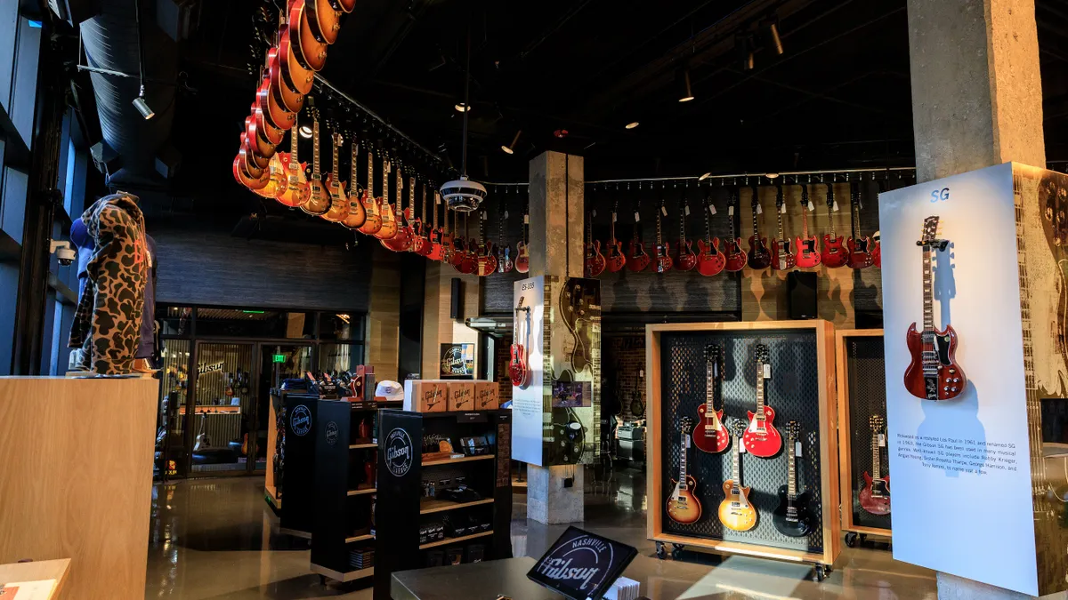 Interior of the Gibson Garage with guitars hanging from the ceiling and in the middle of the store.