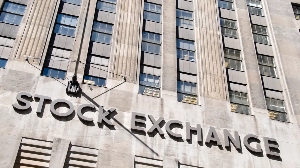 Low angle view of the Stock Exchange sign on the facade of the New York Stock Exchange on Wall street, Manhattan.