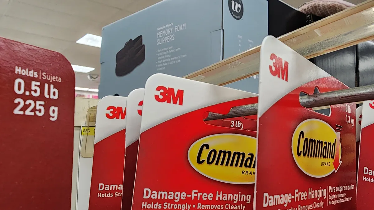 A row of 3M's Command Brand in red packaging on a store aisle.