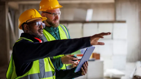 Two construction workers having a conversation on a jobsite.