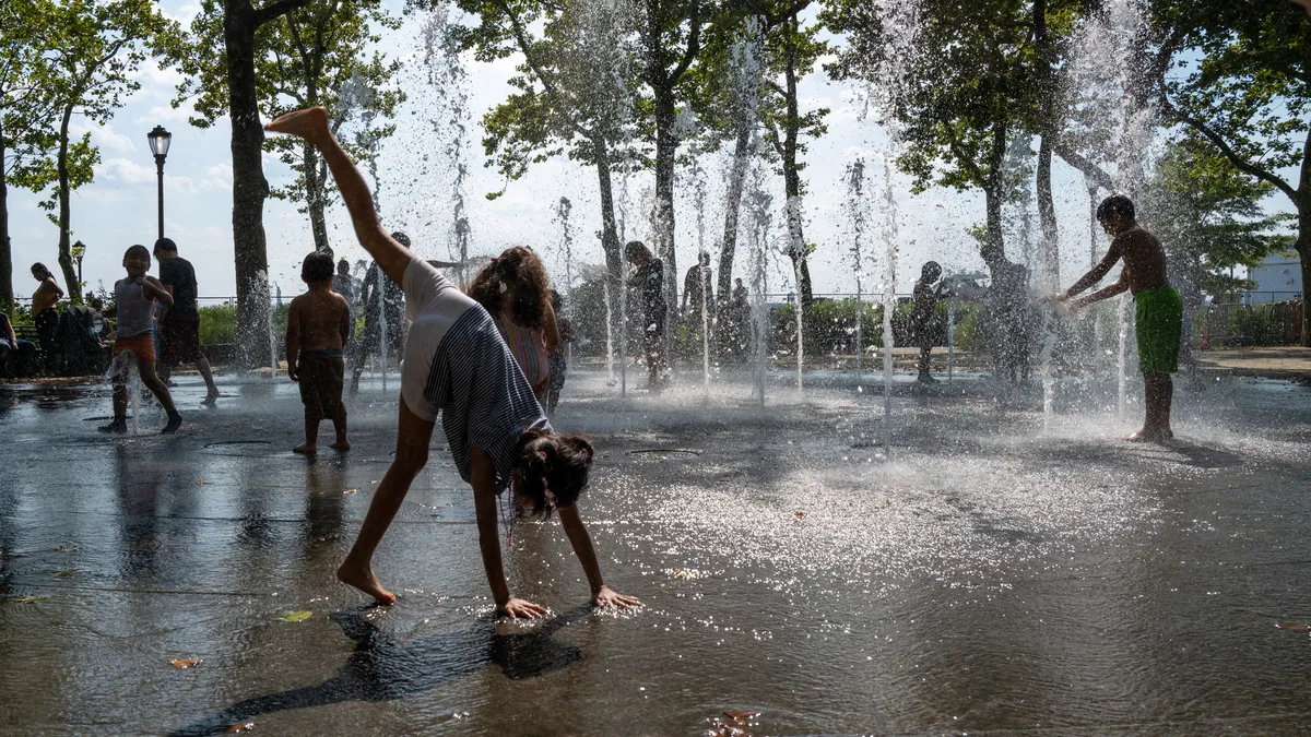 Children cool off in a fountain in a park on a hot afternoon in Manhattan.